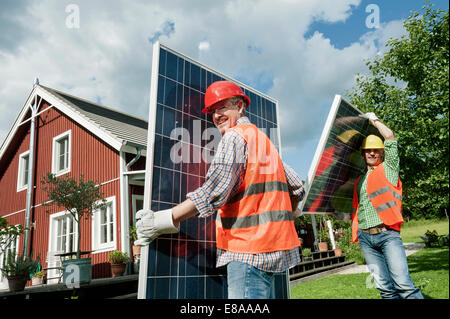 Due operai installazione pannello solare house Foto Stock