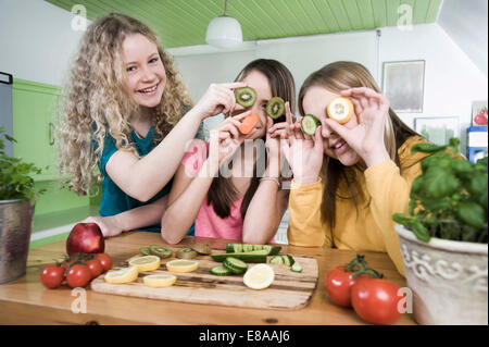Ragazze in cucina a fare ritratti con frutta Foto Stock
