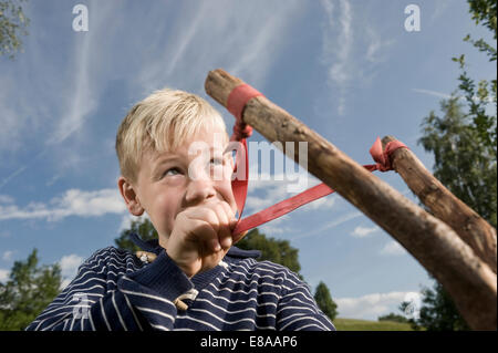 Scopo del ragazzo slingshot sky azienda ritratto Foto Stock