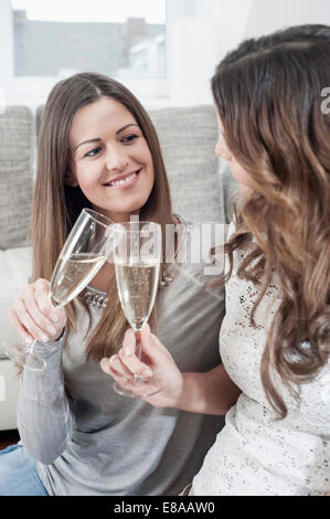 Due giovani donne la tostatura con bicchieri di champagne Foto Stock