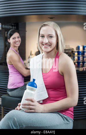 Sorridente giovane donna presso il bar della palestra Foto Stock