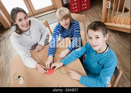 Ritratto di due ragazzi giocare e babysitting femmina assistant Foto Stock