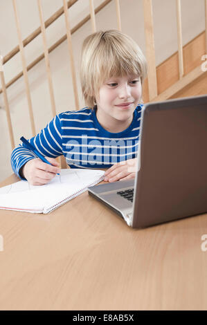 Boy utilizzando laptop per svolgere i suoi compiti Foto Stock