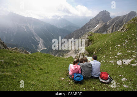 Padre e figli guardando Mappa di escursioni sulle montagne Foto Stock