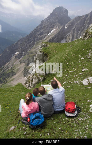 Padre e figli guardando Mappa di escursioni sulle montagne Foto Stock