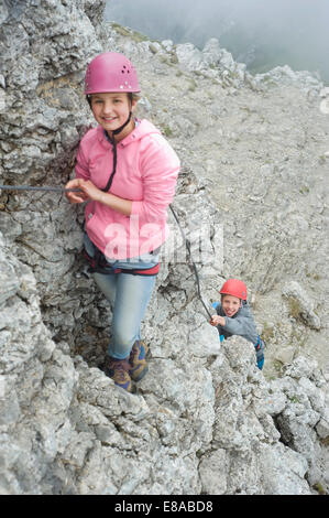 Giovane ragazza adolescente tenendo la corda arrampicata in montagna Foto Stock