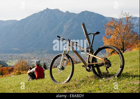 Mountainbiker in appoggio sull'erba godendo di view Foto Stock