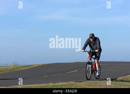 Anziani, maschi ciclista a cavallo, lungo un sentiero costiero di Blackpool, Lancashire, Regno Unito Foto Stock