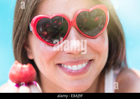 Close up ritratto di giovane donna di mangiare fragole Foto Stock