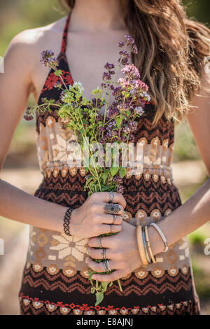 Ritagliato colpo di giovane donna holding mazzetto di fiori di campo Foto Stock