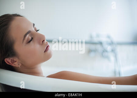 Close up di serena giovane donna addormentato nella vasca da bagno Foto Stock