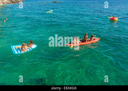 I turisti in kayak il traino di materasso, Jagodna village, isola di Hvar, Croazia Foto Stock