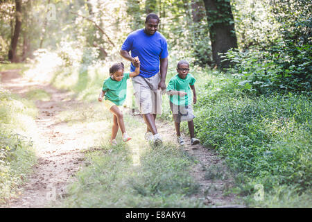 Padre camminare attraverso la foresta con la figlia e il figlio a eco camp