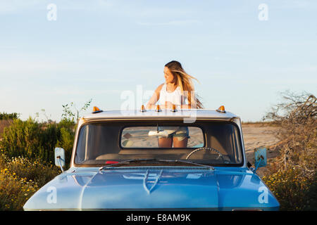 Giovane donna guarda dalla parte posteriore del carrello di prelievo Foto Stock