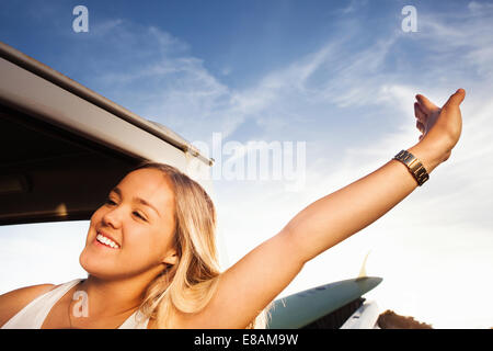 Giovani femmine surfer stretching accanto al carrello elevatore di prelievo Foto Stock