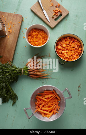 Tagliato a pezzi, affettato, grattugiato e il mazzetto di carote sul banco di cucina Foto Stock