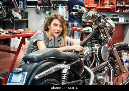 Ritratto di donna meccanico in officina del motociclo Foto Stock