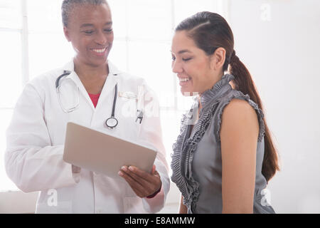 Medico donna che mostra il paziente digitale compressa Foto Stock