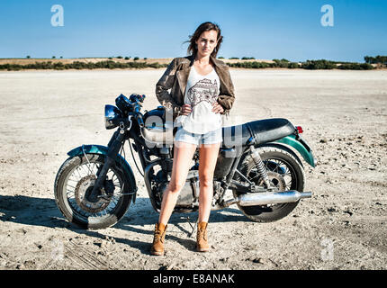 Ritratto di donna motociclista sulla pianura arida, Cagliari, Sardegna, Italia Foto Stock