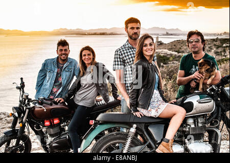 Ritratto di cinque amici di motociclismo sulla costa al tramonto, Cagliari, Sardegna, Italia Foto Stock