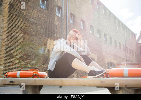 Donna in abbigliamento sportivo, edificio in background Foto Stock