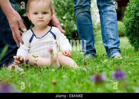 Ritratto di baby ragazza seduta sul prato staring Foto Stock