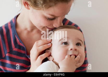 Madre nuzzling baby boy sulla testa Foto Stock