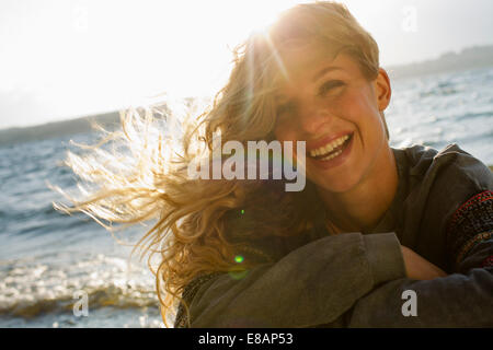 Donna tutti avvolti su windy beach Foto Stock