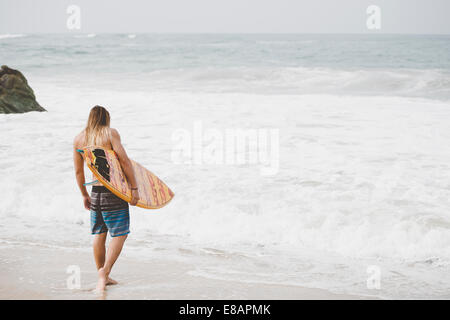 Australian surfer con tavola da surf, Bacocho, Puerto Escondido, Messico Foto Stock