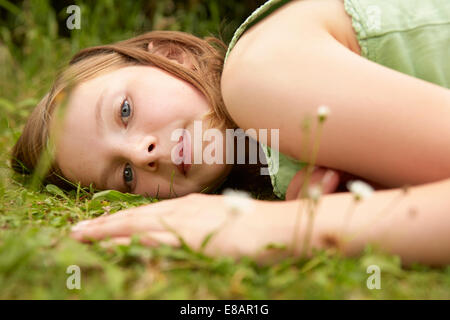 Close up ritratto di ragazza distesa sul giardino di erba Foto Stock