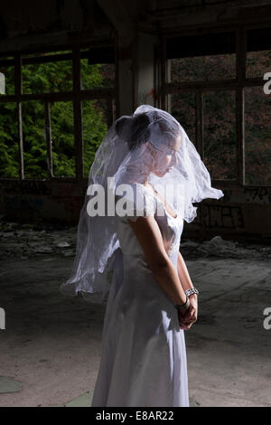 Ritratto di sposa in vuoto interno abbandonati Foto Stock