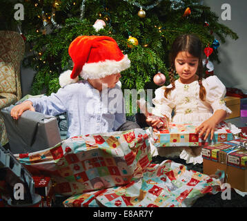 I bambini di aprire i regali di natale Foto Stock