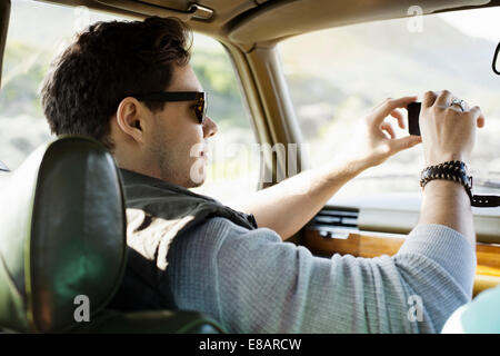 Giovane uomo fotografando attraverso il parabrezza, Cape Town, Western Cape, Sud Africa Foto Stock