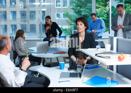 Sei colleghi che lavorano in ufficio occupato Foto Stock