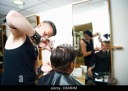 Studente maschio barbiere il taglio mans capelli in college parrucchieri Foto Stock