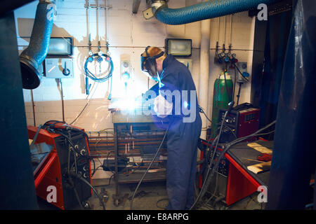 Studente maschio saldatore saldatura in officina college Foto Stock