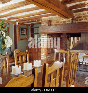 Sedie di legno e tavolo in cottage di travi di sala da pranzo con caminetto Foto Stock