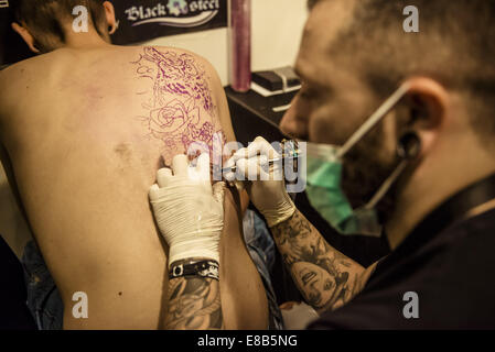 Ottobre 3, 2014 - Tattoo Artist ASTIN, Cordoba, funziona su un uomo con la schiena tatuaggio al XVII International Barcellona Tattoo Expo. © Matthias Oesterle/ZUMA filo/ZUMAPRESS.com/Alamy Live News Foto Stock