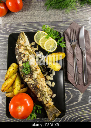 Trota fritta con mandorle, aneto e Spicchi di patate Foto Stock