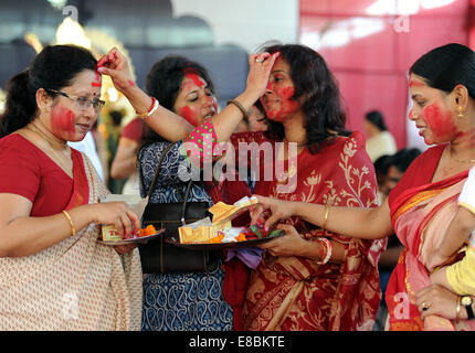 New Delhi, India. 4 Ott 2014. Indian donne Indù applicare vermiglio su ogni altro durante l'ultimo giorno del Durga Puja festival presso una puja pandal in New Delhi, India, il 4 ottobre, 2014. Il festival commemora il massacro di un demone re da lion-riding, dieci-armati dea Durga, segna il trionfo del bene sul male. Credito: Partha Sarkar/Xinhua/Alamy Live News Foto Stock