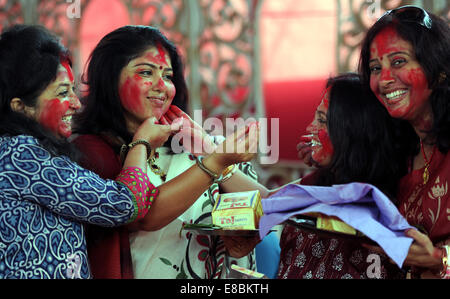 New Delhi, India. 4 Ott 2014. Indian donne Indù applicare vermiglio su ogni altro durante l'ultimo giorno del Durga Puja festival presso una puja pandal in New Delhi, India, il 4 ottobre, 2014. Il festival commemora il massacro di un demone re da lion-riding, dieci-armati dea Durga, segna il trionfo del bene sul male. Credito: Partha Sarkar/Xinhua/Alamy Live News Foto Stock