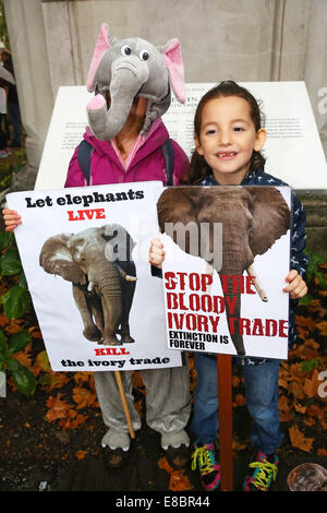 Londra, Regno Unito. Il 4 ottobre 2014. Dimostranti con cartelli e striscioni al Global March per elefanti e rinoceronti, Londra, Inghilterra. La pioggia non ha smorzare gli spiriti dei dimostranti la sensibilizzazione nei confronti della situazione di elefanti e rinoceronti che tra le altre cose vengono uccisi dai cacciatori di frodo per l'avorio e negozio di souvenir. Credito: Paul Brown/Alamy Live News Foto Stock