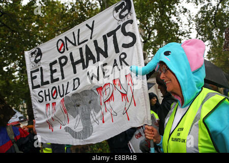 Londra, Regno Unito. Il 4 ottobre 2014. Dimostranti con cartelli e striscioni al Global March per elefanti e rinoceronti, Londra, Inghilterra. La pioggia non ha smorzare gli spiriti dei dimostranti la sensibilizzazione nei confronti della situazione di elefanti e rinoceronti che tra le altre cose vengono uccisi dai cacciatori di frodo per l'avorio e negozio di souvenir. Credito: Paul Brown/Alamy Live News Foto Stock