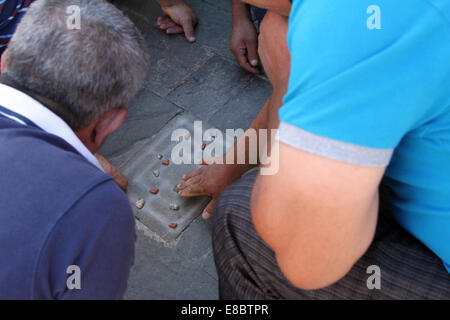 Gli uomini che giocano una partita di "titzmitz' nel centro di Tirana, Albania Foto Stock