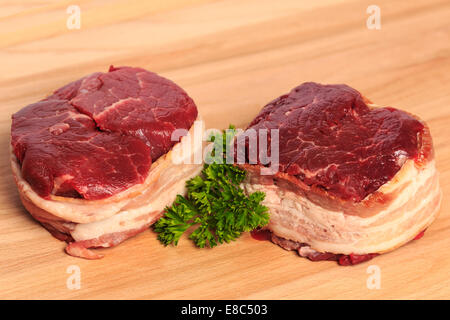 Due 8oz filet mignon bistecche di manzo avvolto con pancetta affumicata su un legno tagliere. Foto Stock