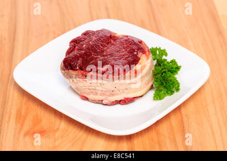 Due 8oz filet mignon bistecche di manzo avvolto con pancetta affumicata su un legno tagliere. Foto Stock