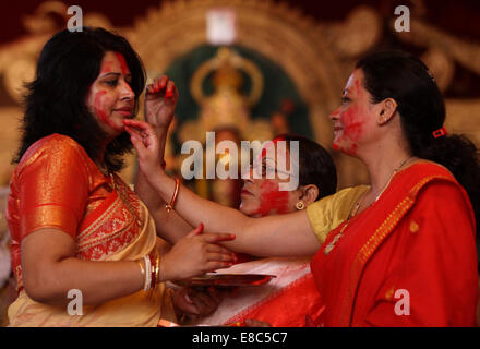 New Delhi, India. 4 Ott 2014. Indian donne Indù applicare vermiglio su ogni altro durante l'ultimo giorno del Durga Puja festival presso una puja pandal in New Delhi, India, il 4 ottobre, 2014. Il festival commemora il massacro di un demone re da lion-riding, dieci-armati dea Durga, segna il trionfo del bene sul male. © Partha Sarkar/Xinhua/Alamy Live News Foto Stock