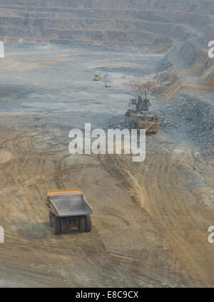 Un grosso escavatore Liebherr haul carichi di camion con ore presso un grande cast aperto africano miniera di rame mentre un carrello Caterpillar attende. Foto Stock