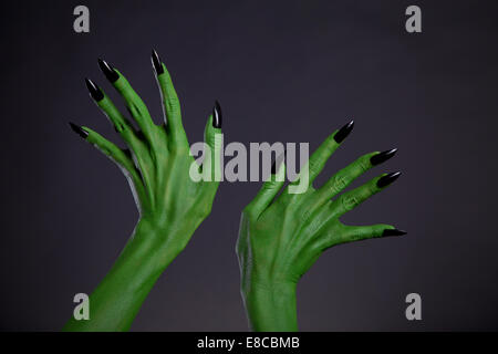 Green monster mani con unghie nere, tema Halloween, studio shot su sfondo nero Foto Stock