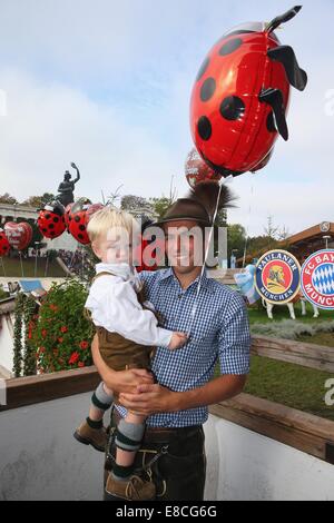 Monaco di Baviera, Germania. 5 Ottobre, 2014. Dispensa - Philipp Lahm assiste con suo figlio Julian il festival della birra Oktoberfest in corrispondenza della Kaefer Wiesnschaenke tenda a Theresienwiese il 5 ottobre 2014 a Monaco di Baviera, Germania. Credito: dpa/Alamy Live News Foto Stock